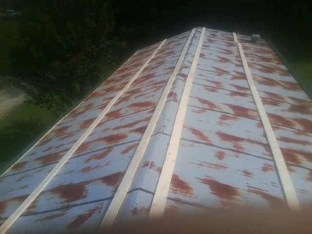 Rusted metal roof panels with new wood purlins before replacement — Storm Damage Roof Repair in Imogene by Roofing Brothers