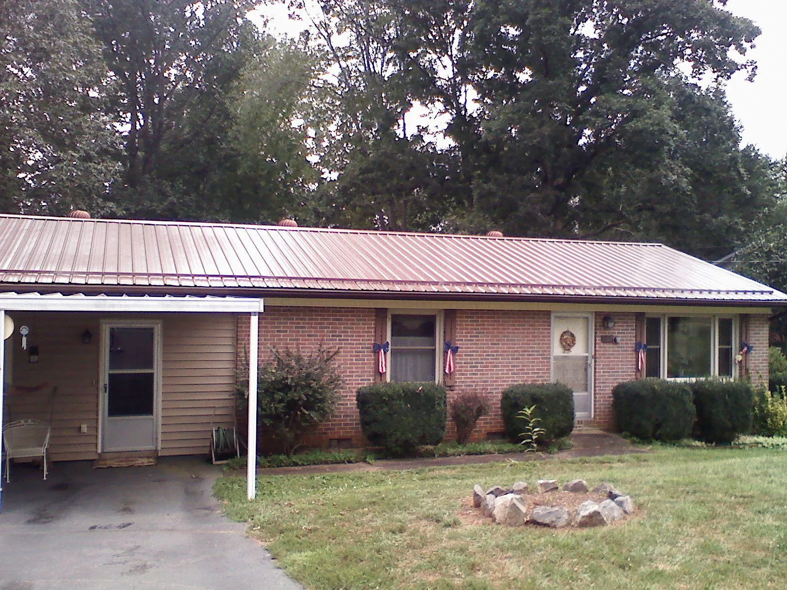 Bronze metal roof and carport on a brick ranch home — Roof Repair work by our crew in Imogene